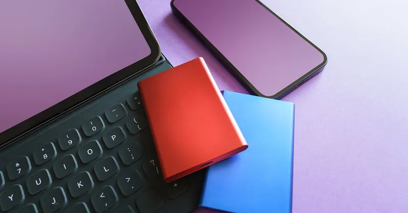 Colorful gadgets including a smartphone, tablet, and SSD on a purple background, ideal for tech-themed projects.